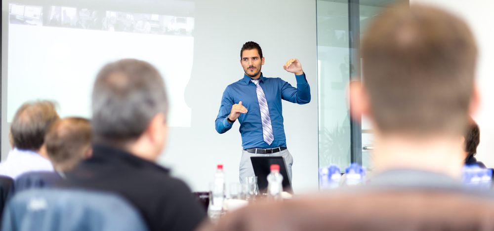 Business executive delivering a presentation to his colleagues during meeting or in-house business training, explaining business plans to his employees.