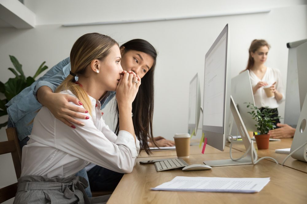 Teammate comforting stressed frustrated female coworker, helping to solve problem online in office