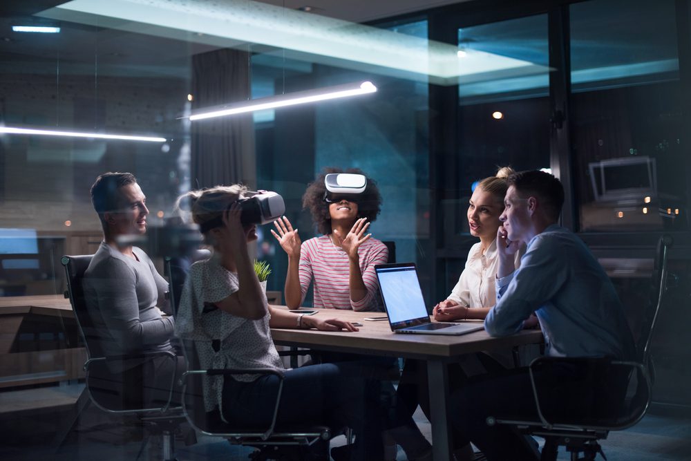 Business team using virtual reality headset in night office meeting Developers meeting with virtual reality simulator around table in creative office
